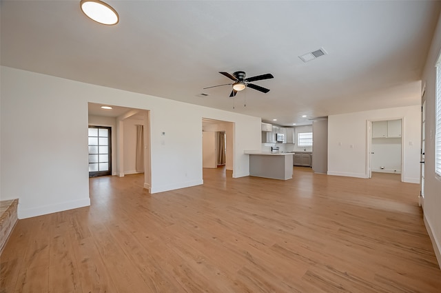 unfurnished living room with light hardwood / wood-style flooring and ceiling fan