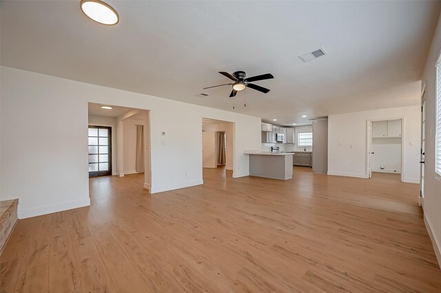 unfurnished living room with ceiling fan and light hardwood / wood-style floors