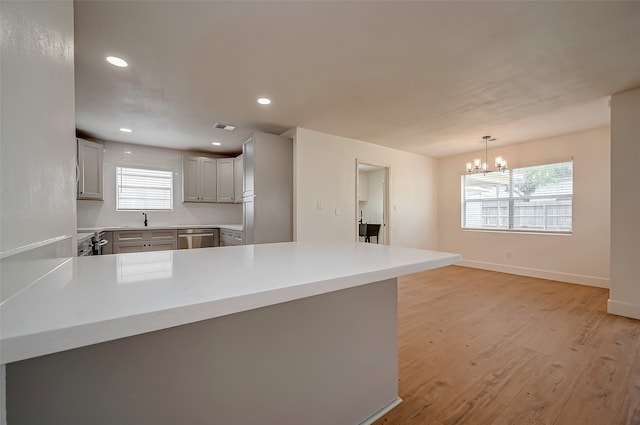 kitchen featuring kitchen peninsula, a healthy amount of sunlight, and light hardwood / wood-style floors