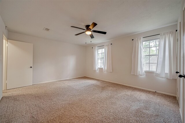 carpeted empty room featuring ceiling fan and a textured ceiling