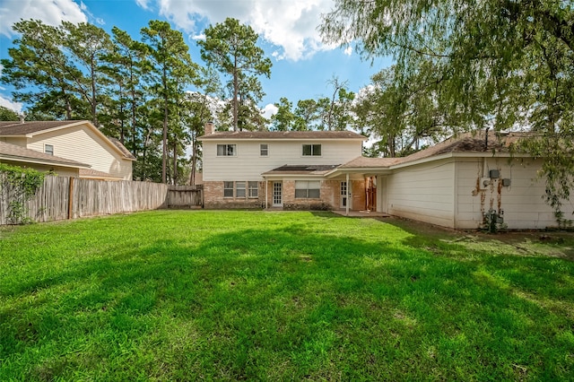 rear view of house featuring a lawn