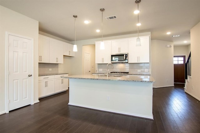 kitchen with backsplash, white cabinetry, a center island with sink, and dark hardwood / wood-style flooring