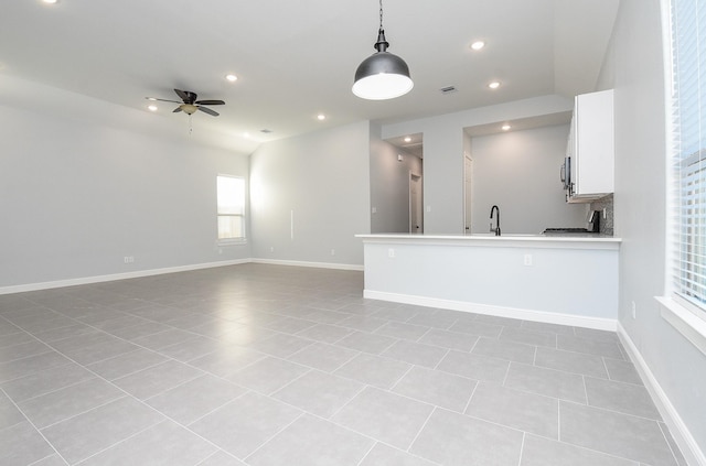 kitchen featuring recessed lighting, a ceiling fan, hanging light fixtures, white cabinets, and open floor plan