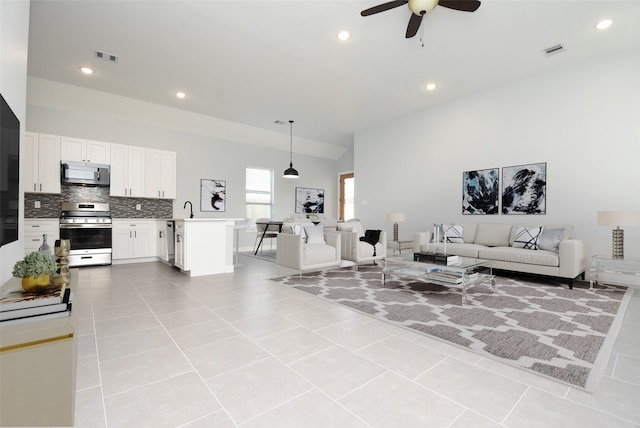 living room with sink, light tile patterned flooring, and ceiling fan