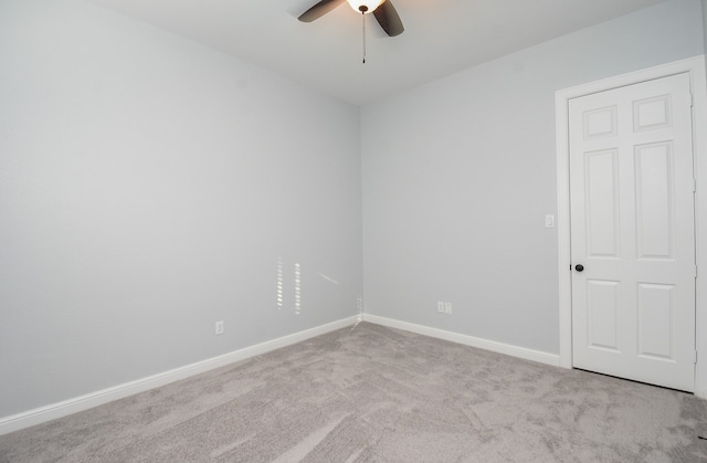 spare room with ceiling fan and light colored carpet