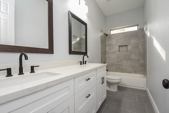 bathroom featuring toilet, tile patterned flooring, double vanity, and a sink
