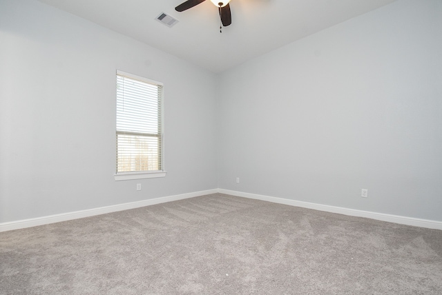 spare room featuring carpet, vaulted ceiling, and ceiling fan