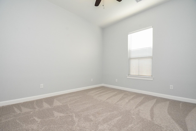 carpeted empty room featuring ceiling fan, lofted ceiling, and baseboards