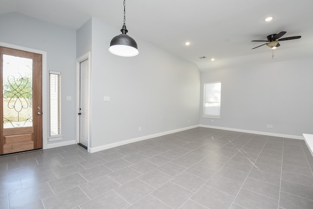 foyer entrance with ceiling fan, vaulted ceiling, and light tile patterned floors