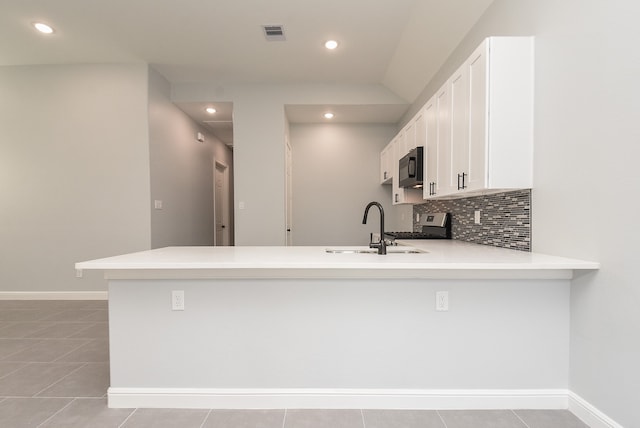 kitchen with sink, white cabinetry, kitchen peninsula, and light tile patterned flooring