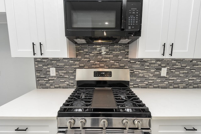 kitchen featuring black microwave, stainless steel gas range, white cabinets, and light countertops