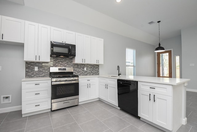 kitchen featuring tasteful backsplash, a sink, light countertops, black appliances, and a peninsula