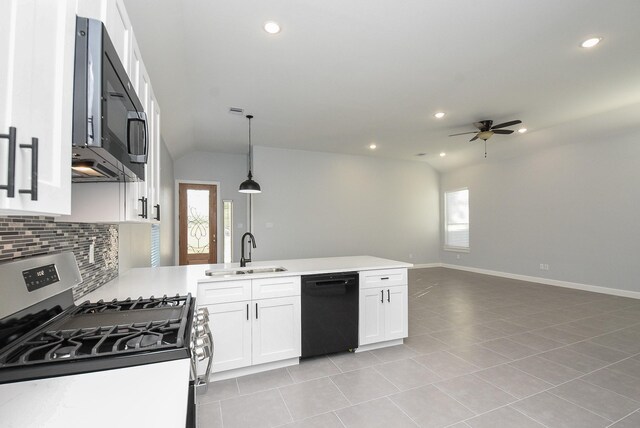 kitchen featuring a sink, a healthy amount of sunlight, stainless steel gas range oven, black dishwasher, and a peninsula