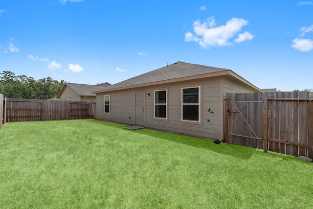 rear view of house featuring a yard