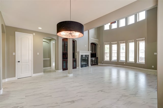 unfurnished living room with a towering ceiling