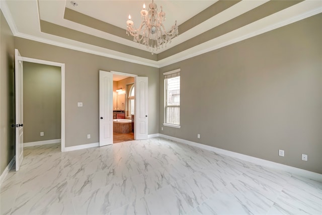 unfurnished bedroom with a notable chandelier, connected bathroom, a tray ceiling, and crown molding