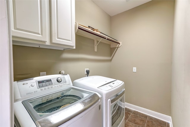 laundry room with cabinets, independent washer and dryer, and dark tile patterned floors