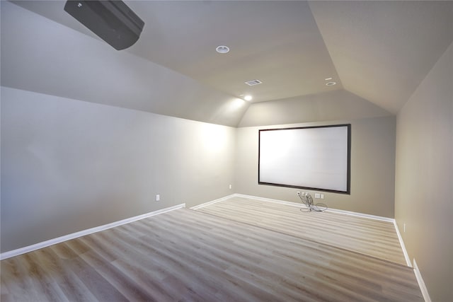 home theater with light wood-type flooring and lofted ceiling