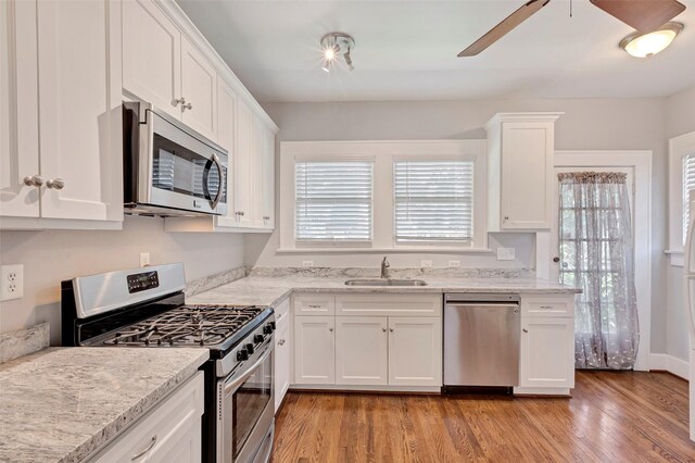 kitchen featuring white cabinetry, sink, appliances with stainless steel finishes, and light hardwood / wood-style flooring