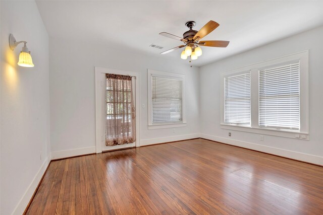 empty room with hardwood / wood-style floors and ceiling fan