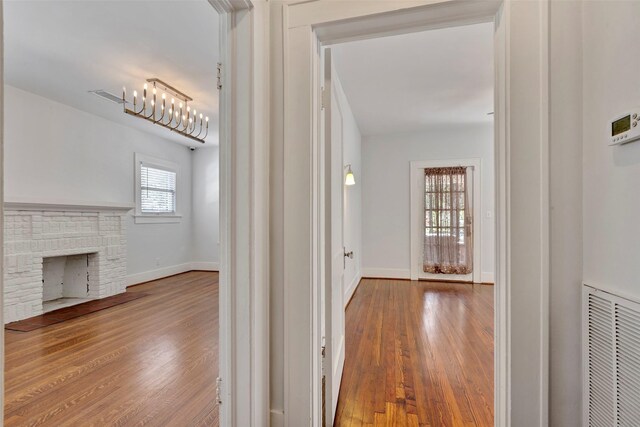 hallway featuring hardwood / wood-style floors and an inviting chandelier