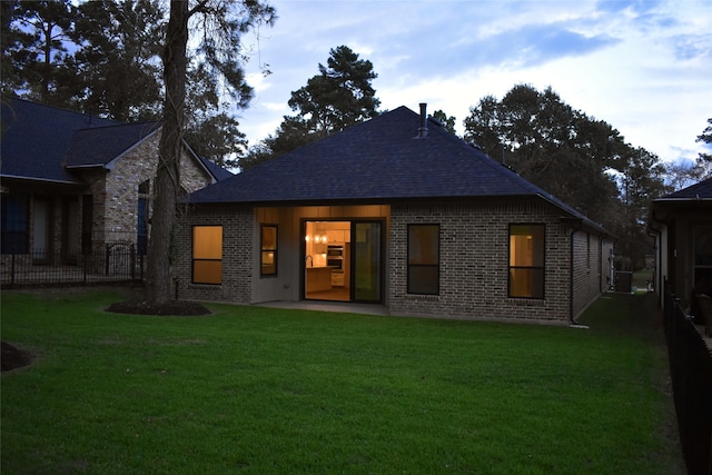 rear view of property featuring a lawn