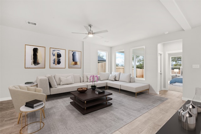 living room with light hardwood / wood-style flooring, ceiling fan, and beam ceiling