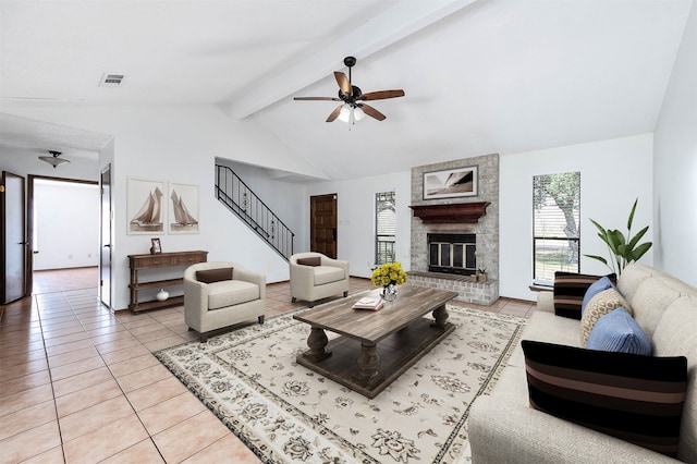 tiled living room featuring ceiling fan, vaulted ceiling with beams, and a fireplace