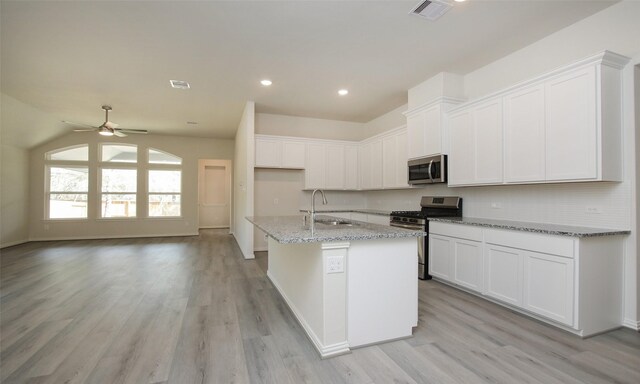 kitchen with sink, white cabinetry, stainless steel appliances, a center island with sink, and ceiling fan