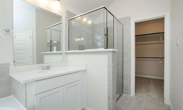 bathroom with vanity, a shower with shower door, and tile patterned floors