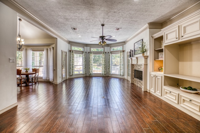 living room with ceiling fan with notable chandelier, a fireplace, dark wood-type flooring, and ornamental molding