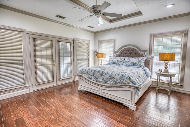 bedroom with a textured ceiling, a raised ceiling, crown molding, ceiling fan, and access to exterior