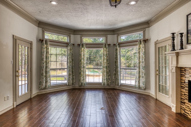 interior space featuring a fireplace, a textured ceiling, crown molding, and dark hardwood / wood-style flooring