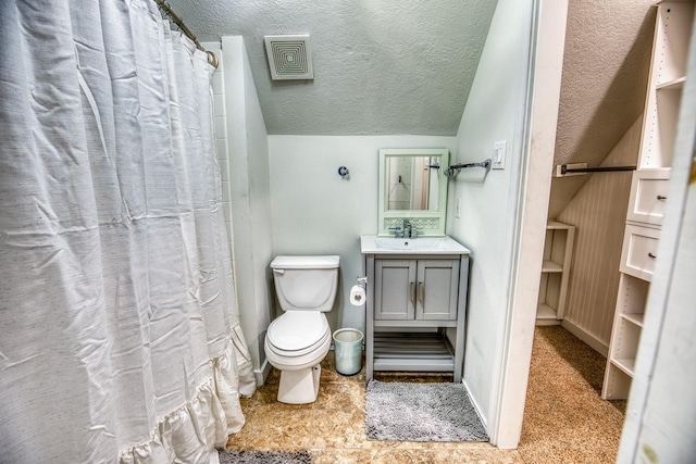 bathroom with toilet, vaulted ceiling, and vanity