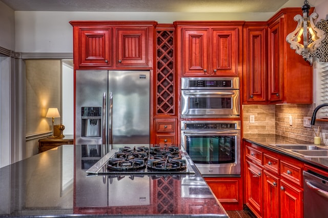 kitchen with appliances with stainless steel finishes, decorative backsplash, and sink