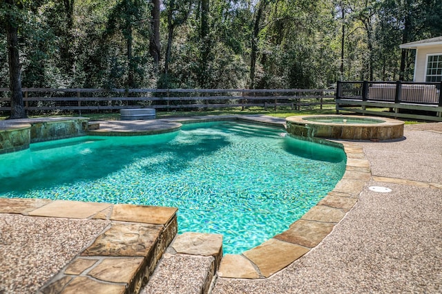 view of swimming pool with an in ground hot tub