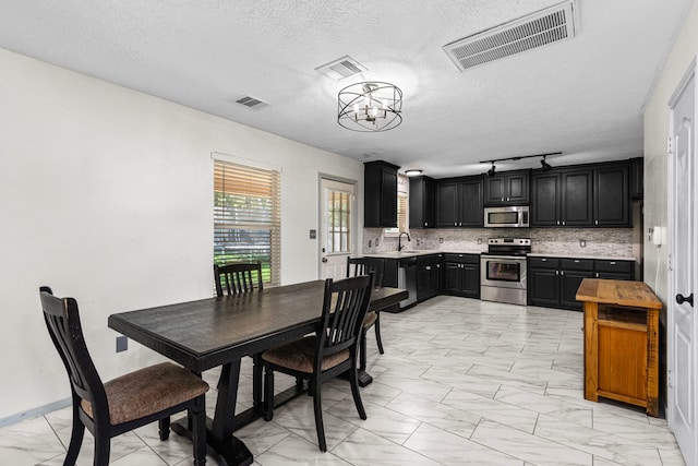 interior space featuring an inviting chandelier, a textured ceiling, and sink