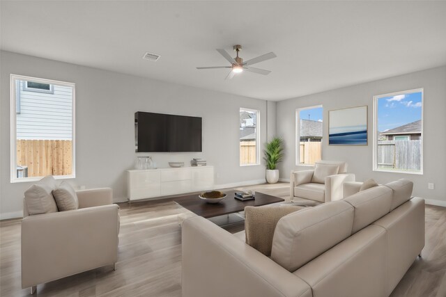 living room with light hardwood / wood-style floors and ceiling fan