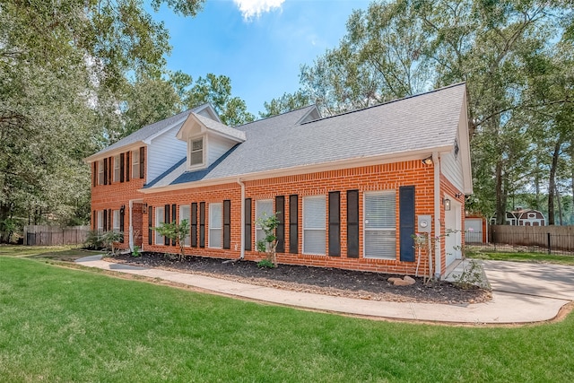 rear view of property featuring a garage and a lawn