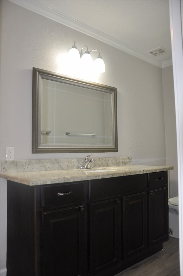 bathroom featuring ornamental molding, vanity, toilet, and wood-type flooring