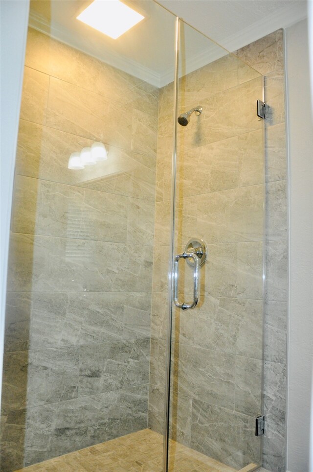 bathroom featuring crown molding and an enclosed shower