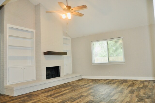 unfurnished living room featuring ceiling fan, built in shelves, dark wood-type flooring, high vaulted ceiling, and a fireplace