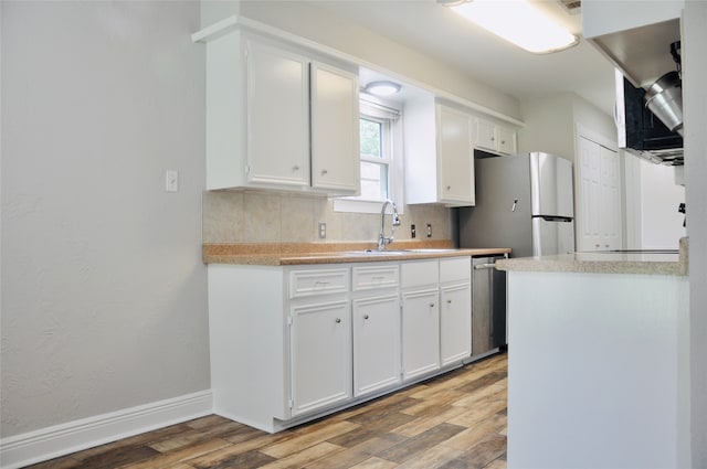 kitchen featuring appliances with stainless steel finishes, white cabinetry, sink, and hardwood / wood-style flooring