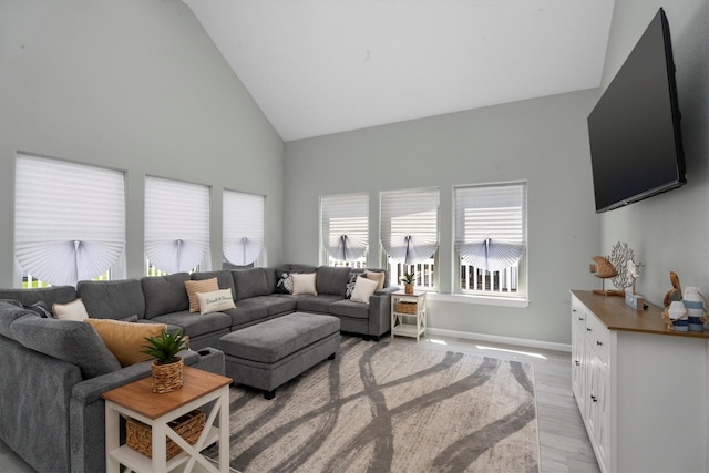 living room with light hardwood / wood-style floors and high vaulted ceiling