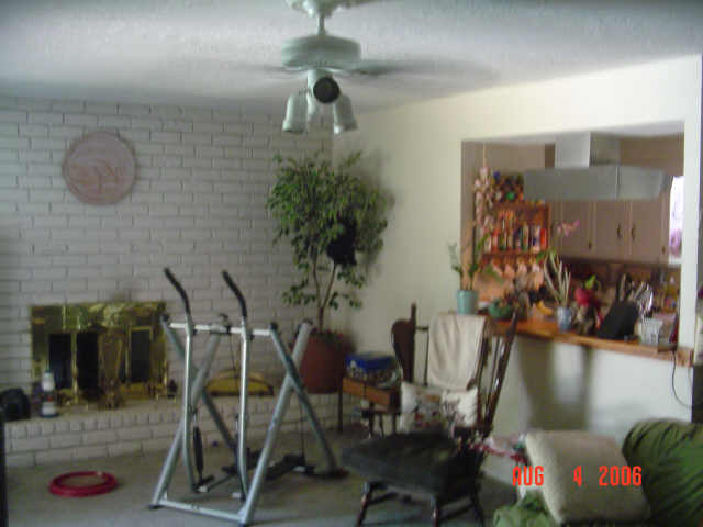 miscellaneous room featuring ceiling fan and brick wall