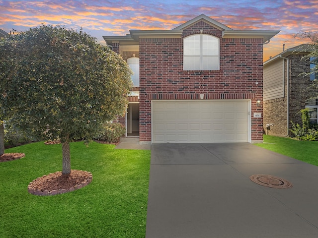 front of property with a garage and a lawn