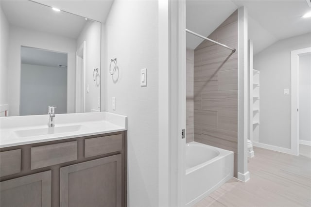 bathroom with toilet, vanity, and baseboards