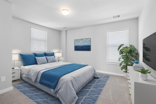 bedroom featuring carpet floors, visible vents, multiple windows, and baseboards