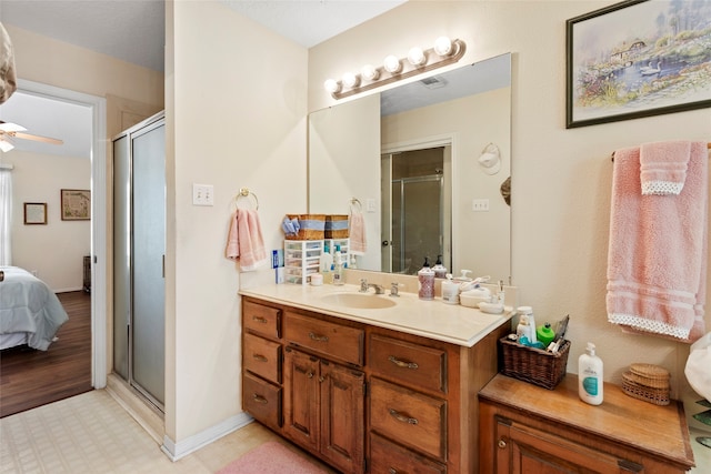 bathroom with wood-type flooring, vanity, ceiling fan, and a shower with shower door