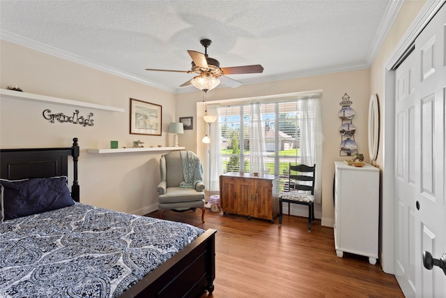 bedroom with ceiling fan, hardwood / wood-style flooring, a closet, and crown molding